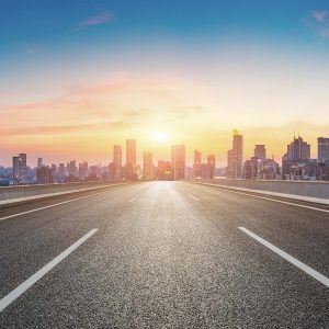 Empty asphalt road and city skyline